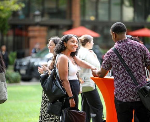 students networking outdoors, shaking hands